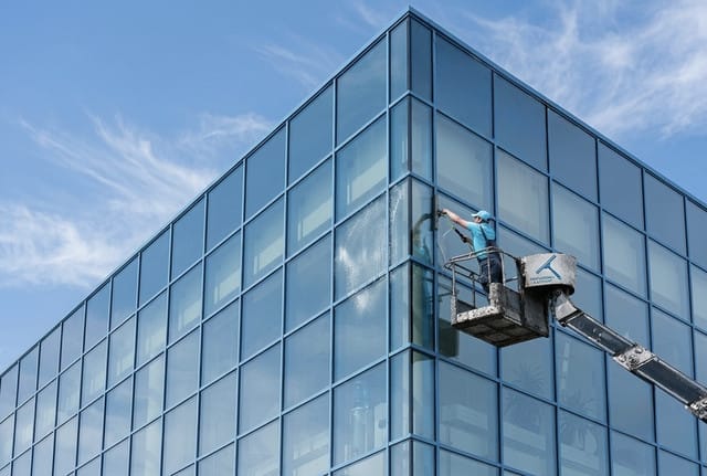 Glasreiniger an einer Fensterfront